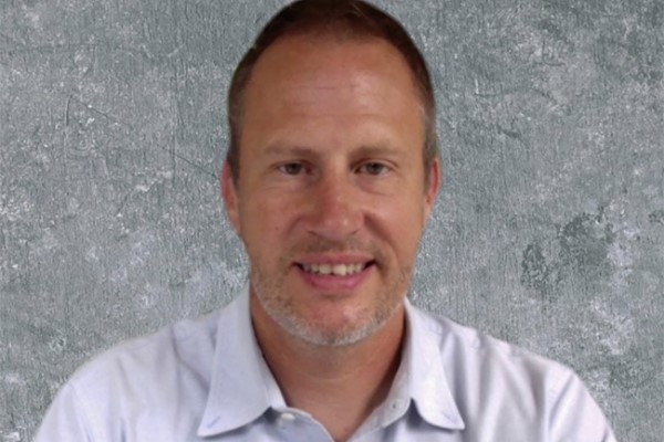 Image of Brian Overholser, PharmD, smiling for the camera in front of a grey backdrop