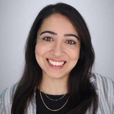 Anita Panjwani smiles in her headshot. She has dark brown hair and brown eyes, and wears a light colored striped top over a black shirt.