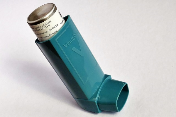 a blue inhaler against a white background