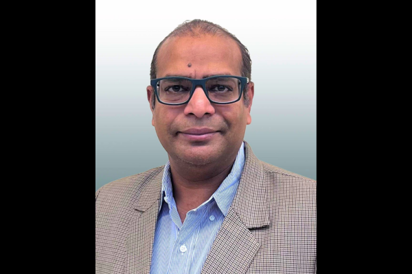 Mangilal Agarwal smiles in his headshot.