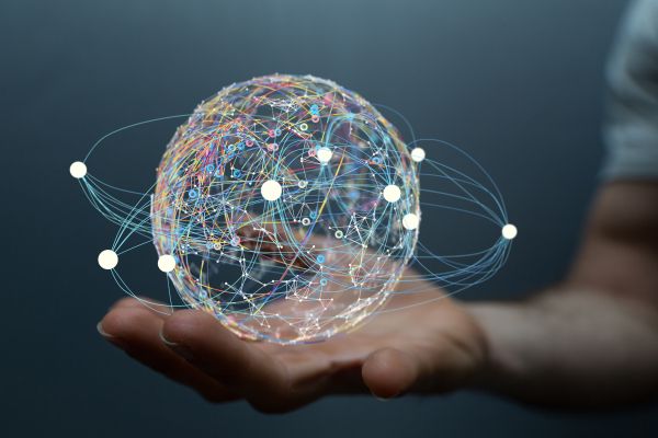 A hand holds a visualized globe with data points