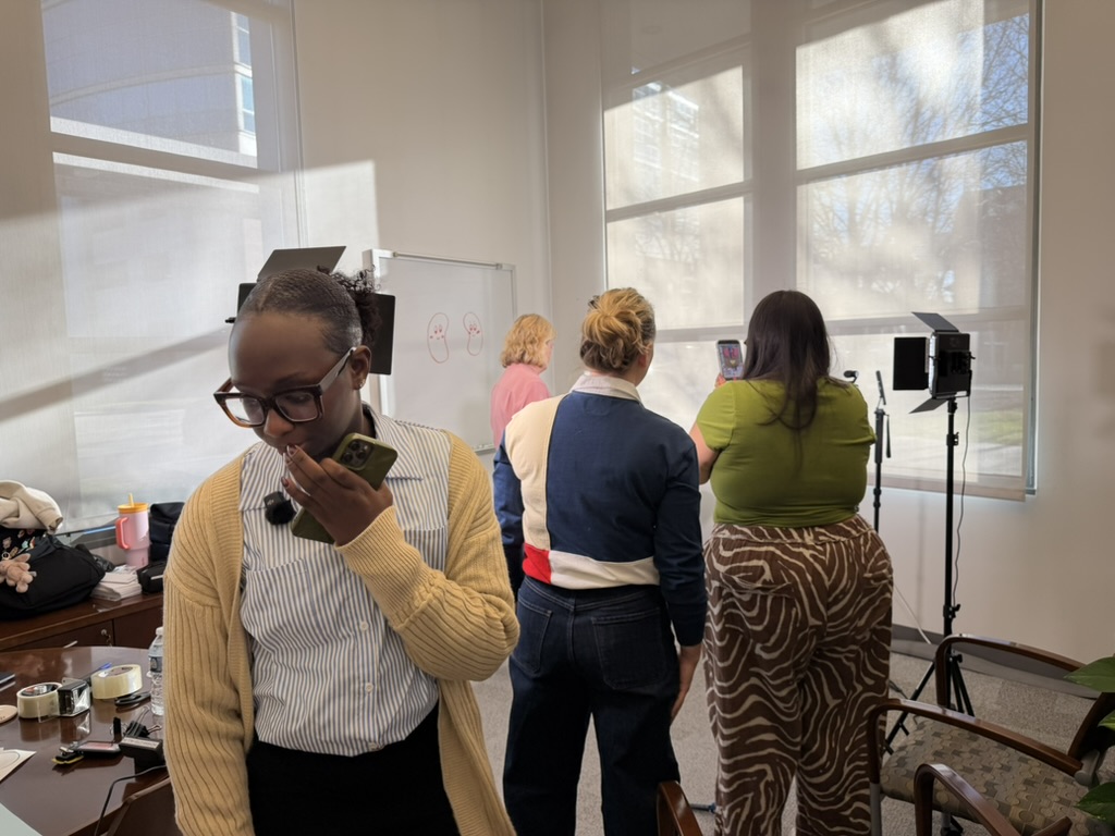 Fatma Niang heading to door. Lynsey and Bonnie view Sharon Moe through phone camera. 