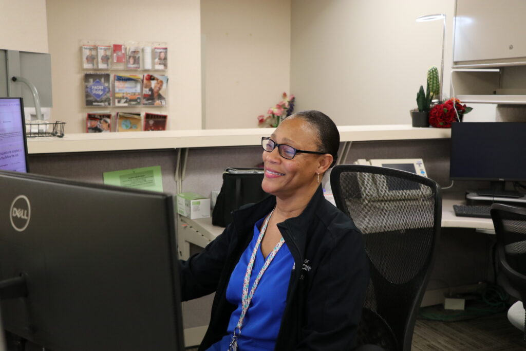 Nora Watts doing administrative work at the outpatient reception desk.