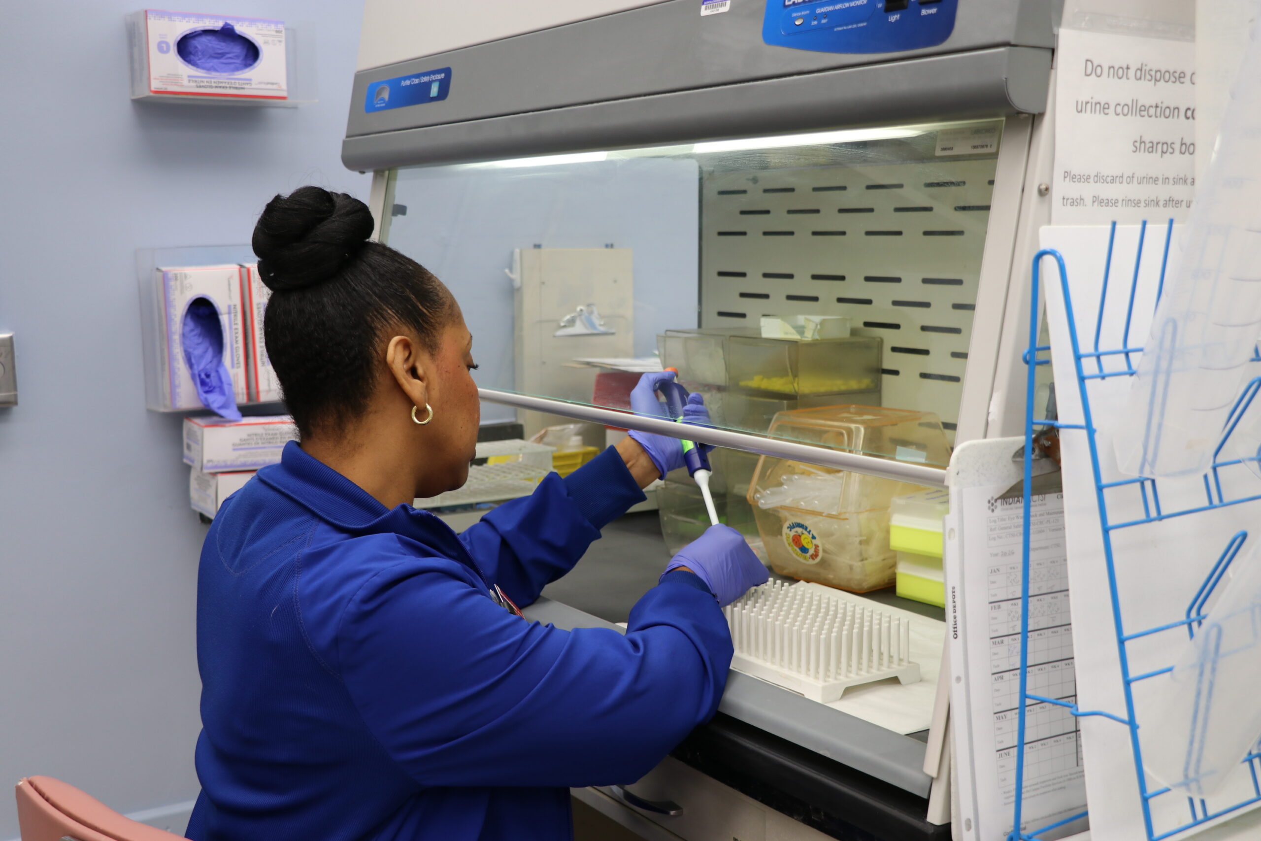 Nurse April Deloney works with a pipette in the lab.