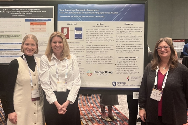 Three poster presenters in front of their poster.