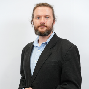 Radoslaw Kaczmarek smiles in his headshot.