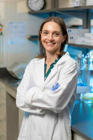 Dr. Katrina Adams smiles in a headshot taken in front of her laboratory bench.