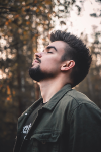 young man with beard takes a deep breath