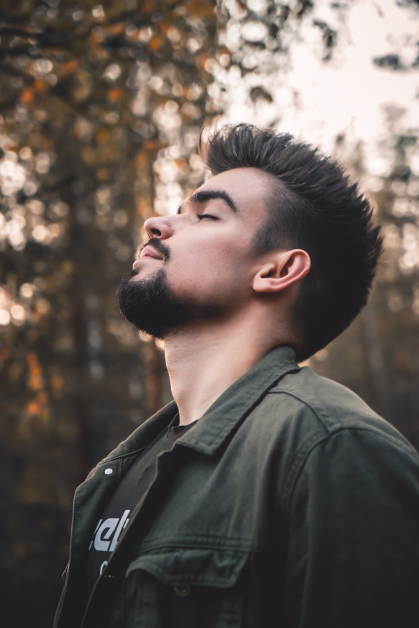 young man with beard takes a deep breath