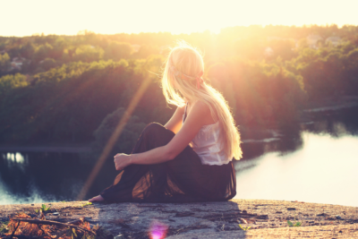 young woman admires sunset in nature