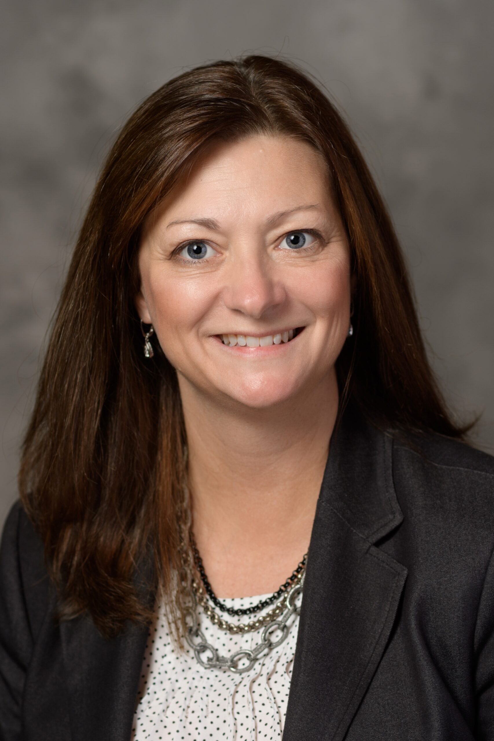 A smiling headshot of Karen Hinshaw, MS in front of a grey mottled background. 