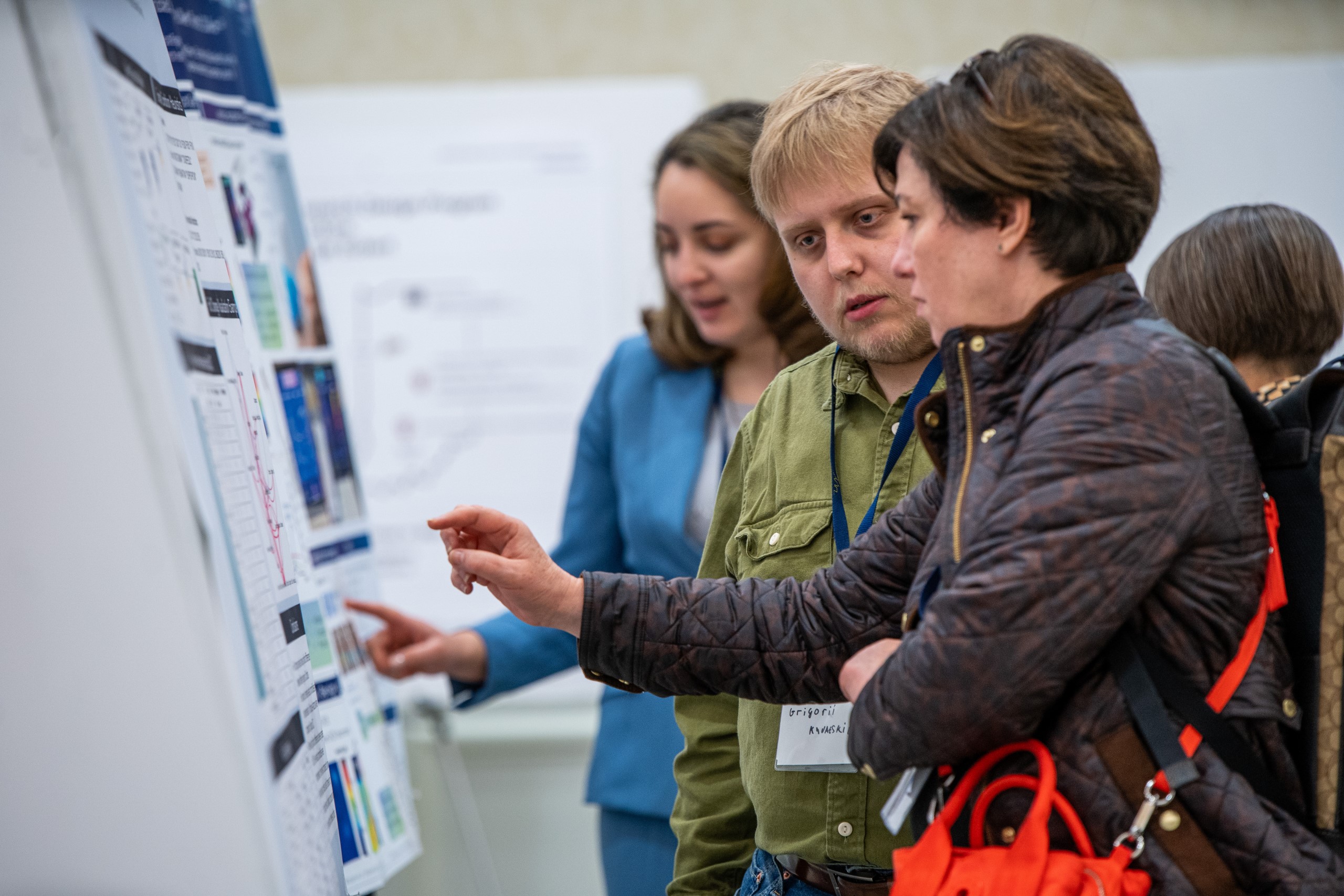 Grigorii Khvatskii answers questions from a poster attendee about his research.