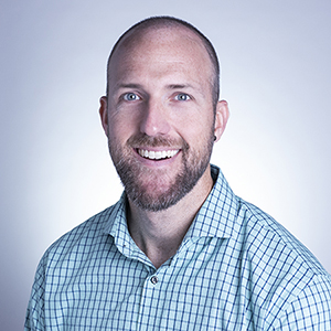 Zac Schlader smiles in his headshot.