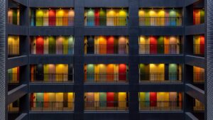 Image shows four floors of apartments with doors of bright colors