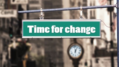 sign that reads time for change with a clock in the background