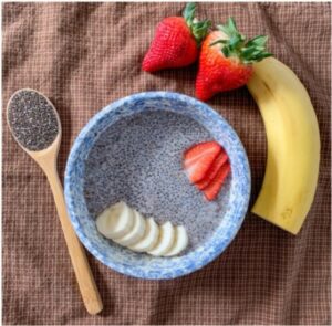 bowl of chia pudding with sliced banana and strawberries