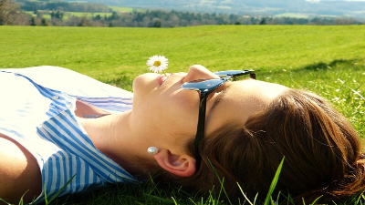 Photo of a person laying in the grass wearing sunglasses