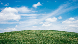 photo of grassy hill and blue cloudy sky