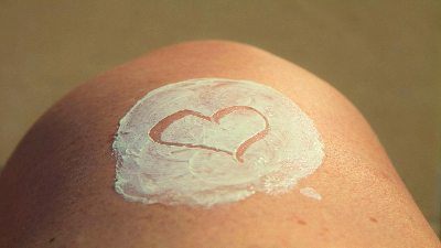 photo of a heart drawn in white sunscreen on skin