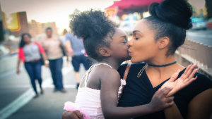 photo of woman kissing a child