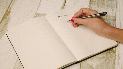 photo of a notebook with the words my plan and a hand with a pen