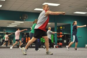 Image shows a fitness class with four individuals kickboxing