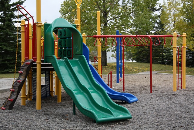 Image shows a playground with colorful slides and monkey bars