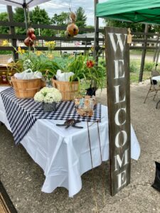 A table with vegetables and a welcome sign next to it at the Eugene Station in Vermillion County Indiana 